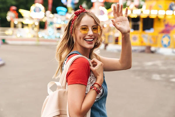 Bild av charmig blond kvinna leende och vinka på kameran i f — Stockfoto