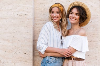 Neşeli mutlu gülümseyen pozitif genç kız arkadaşlar açık havada sarılma poz.