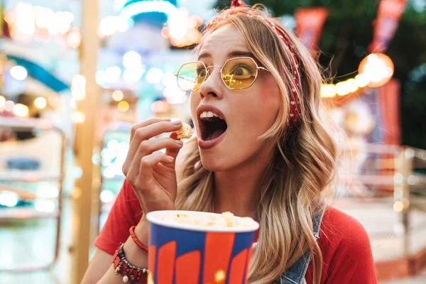 Image of surprised blonde woman rejoicing and holding popcorn wh — ストック写真