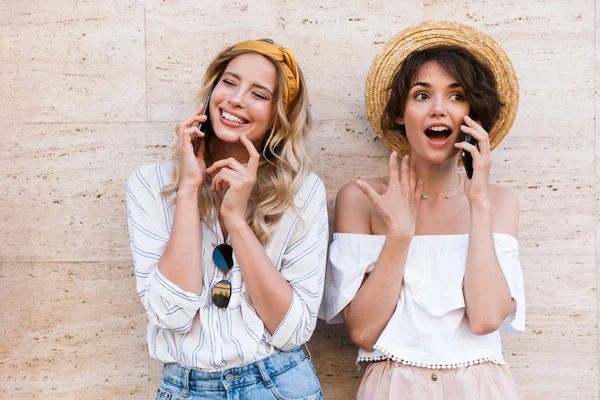 Sonriente alegre alegre positivo jóvenes amigas al aire libre hablando por teléfonos móviles . — Foto de Stock