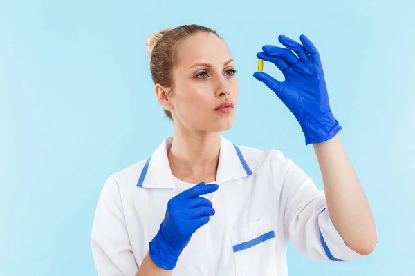 Schöne blonde Ärztin in Uniform stehend — Stockfoto