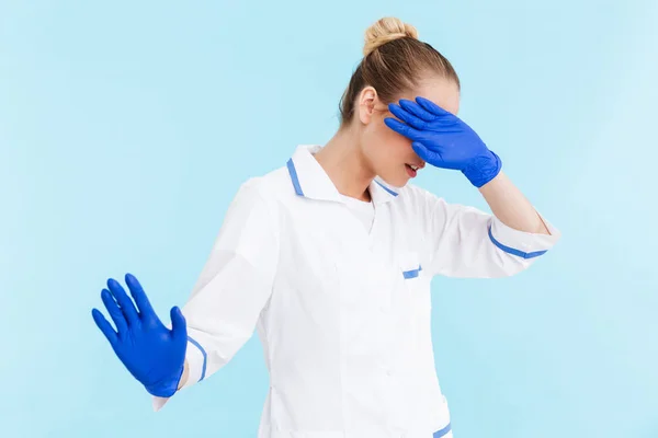 Schöne blonde Ärztin in Uniform stehend — Stockfoto