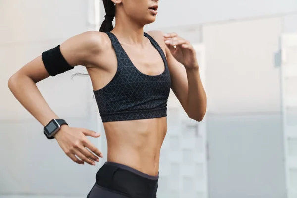 Imagem recortada de uma jovem atleta jogging — Fotografia de Stock