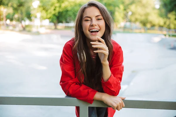 Bild Nahaufnahme einer Studentin, die auf einem Sportplatz lacht und sich an einem Geländer beugt — Stockfoto