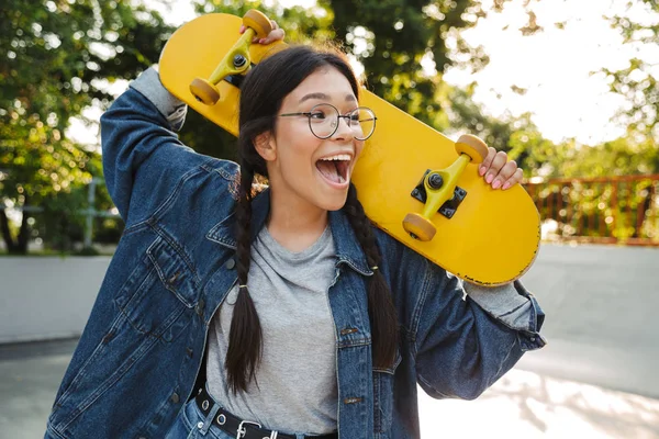 스케이트 공원에서 스케이트 보드를 들고있는 동안 흥분 소녀비명과 기뻐하는 이미지 — 스톡 사진