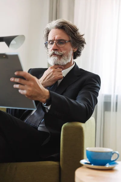 Portrait closeup of serious mature businessman holding clipboard — Stock Photo, Image