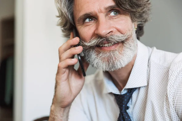 Image closeup of joyful adult man talking on cellphone while sit — Stock Photo, Image