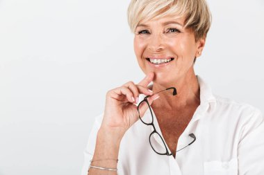 Gözlük tutan ve kameraya bakan mutlu orta yaşlı kadın portresi