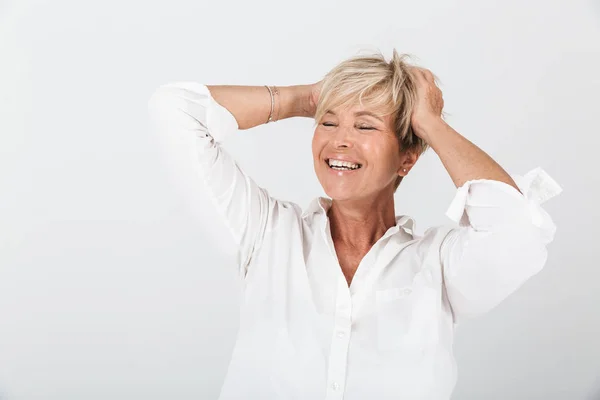 Retrato de mulher adulta alegre com cabelo loiro curto agarrando ele — Fotografia de Stock