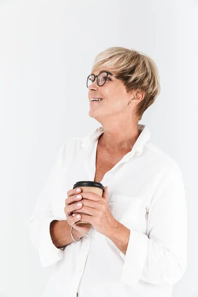Портрет положительной взрослой женщины в очках, держащей чашку кофе на вынос — стоковое фото