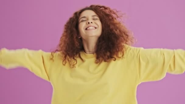 Gelukkig Jonge Redhead Krullend Vrouw Glimlachend Dansen Roze Achtergrond Geïsoleerd — Stockvideo