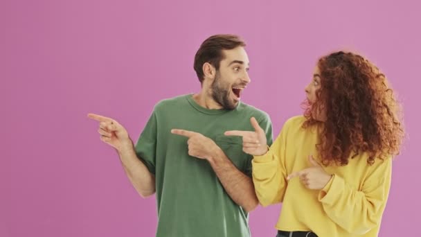 Attractive Positive Young Couple Becoming Surprised Pointing Side Fingers Pink — Stock Video