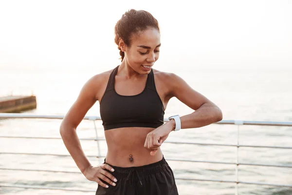 Imagen de una mujer afroamericana bonita mirando su reloj de pulsera —  Fotos de Stock