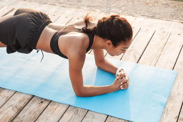 Beeld van atletische vrouw doet plank oefeningen op Finess mat citru — Stockfoto