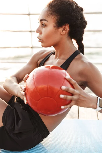 Immagine di donna atletica che fa scricchiolii con palla finess mentre wo — Foto Stock