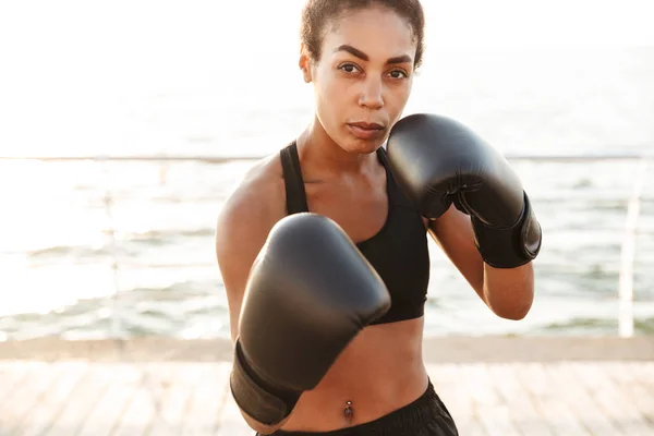 Retrato de mujer bonita y enérgica entrenando en guantes de boxeo por — Foto de Stock