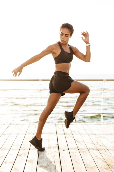 Bild av atletisk ung kvinna i sportiga kläder gör Workout — Stockfoto