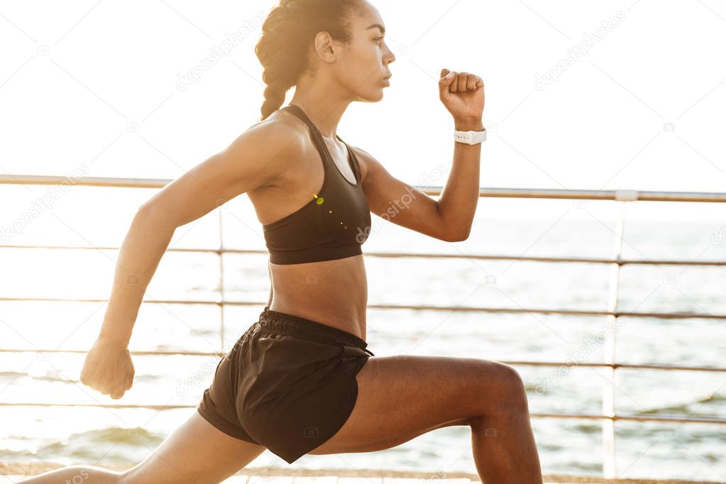 Photo of african american young woman in tracksuit doing workout