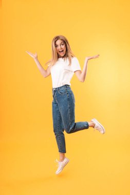 Kameraya gülümseyen ve ellerini kusarak rahat t-shirt giyen iyimser sarışın kadın tam uzunlukta görüntü