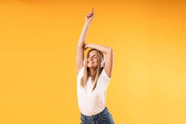 Kulaklıkla müzik dinlerken gülümseyen sevimli sarışın kadının görüntü yakın çekim