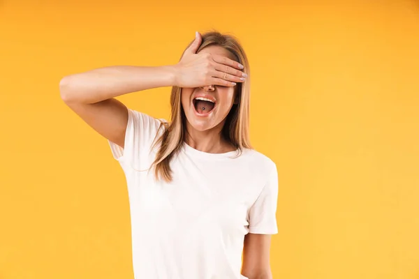 Bild Nahaufnahme einer positiven blonden Frau in lässigem T-Shirt, die lacht und ihre Augen mit der Hand bedeckt — Stockfoto