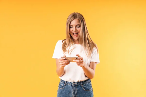 Image gros plan d'une jeune femme optimiste portant un t-shirt décontracté souriant tout en utilisant un smartphone — Photo