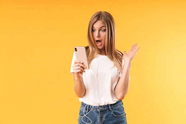 Image gros plan d'une femme blonde excitée exprimant son émerveillement devant un smartphone tout en utilisant des écouteurs — Photo