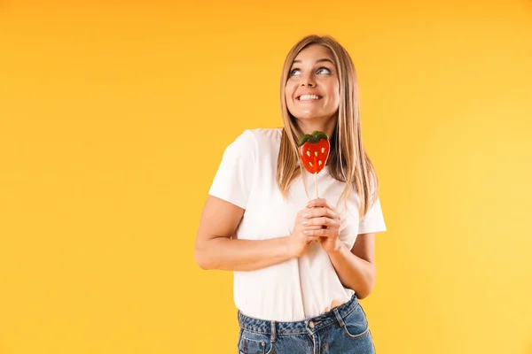 Image closeup of joyous blond woman wearing casual t-shirt looking upward at copyspace while holding paper strawberry — Stock Photo, Image