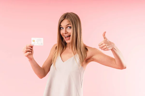 Image closeup of gorgeous blond woman wearing dress smiling and showing thumb up while holding credit card — ストック写真
