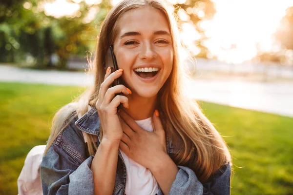 Girl walking outside in nature green park talking by mobile phone. — Stock Photo, Image