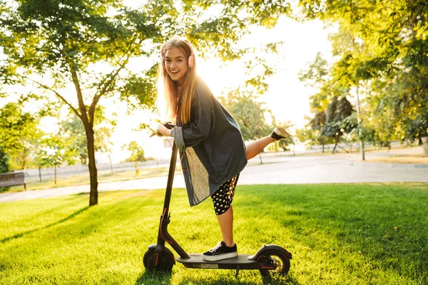 Positivo ottimista giovane ragazza adolescente fuori a piedi con scooter . — Foto Stock