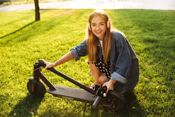 Scooter ile yürüyüş dışında pozitif iyimser genç genç kız. — Stok fotoğraf