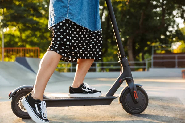Tiener meisje in Park wandelen op scooter. — Stockfoto