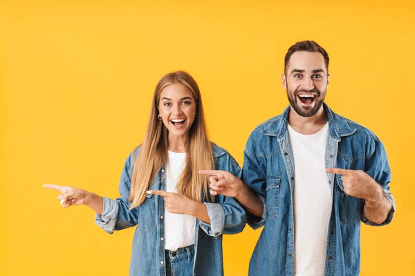 Immagine di una giovane coppia che sorride puntando il dito contro il copyspace — Foto Stock