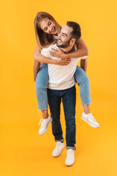 Bild eines schönen Paares, das zusammen lächelt, während es huckepack fährt — Stockfoto