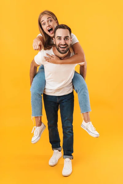 Bild eines kaukasischen Paares, das huckepack mit dem Finger zeigt — Stockfoto