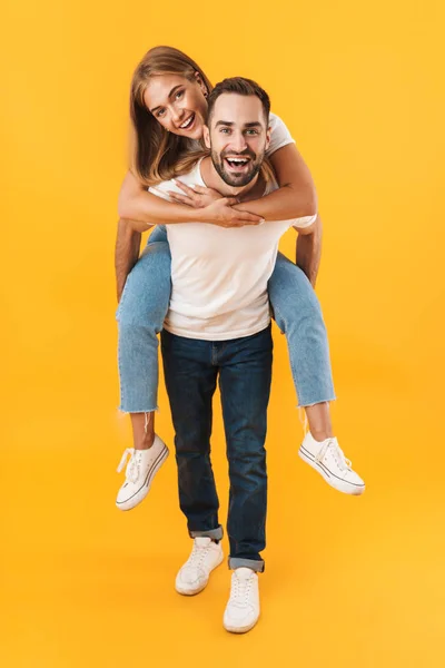 Image of excited couple smiling together while doing piggyback ride — Stockfoto