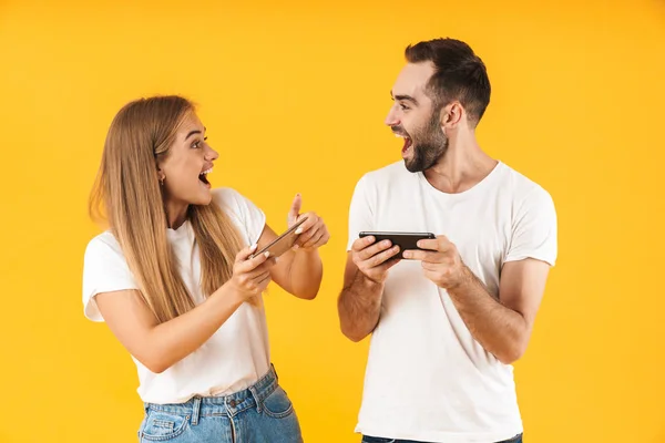 Imagen de pareja alegre jugando videojuegos en smartphones juntos —  Fotos de Stock