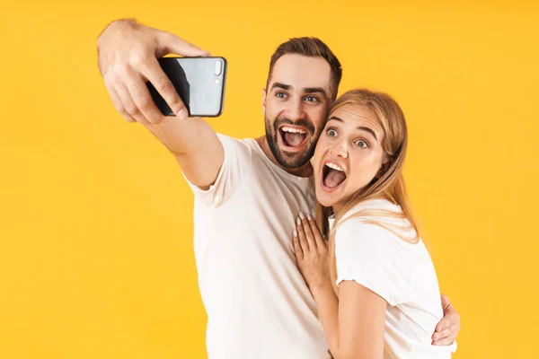 Image of young couple smiling while taking selfie photo on cellphone — Stock Photo, Image
