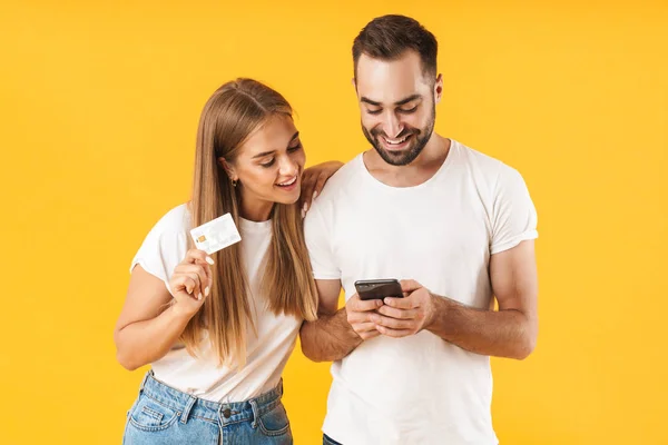スマートフォンやクレジットカードを持ちながら笑顔の楽しいカップルのイメージ — ストック写真