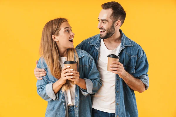 Bild von zufriedenem Paar, das lächelt, während es Kaffeetassen zum Mitnehmen hält — Stockfoto