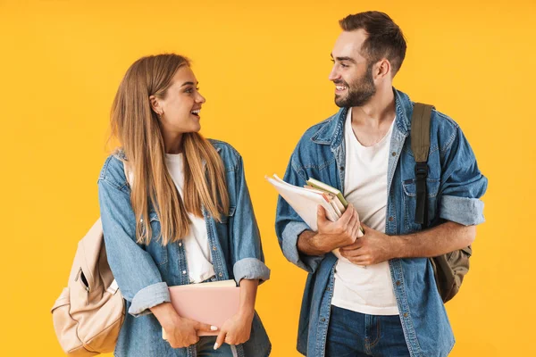 Imagen de hermosos estudiantes sonriendo mientras sostienen libros de ejercicios — Foto de Stock