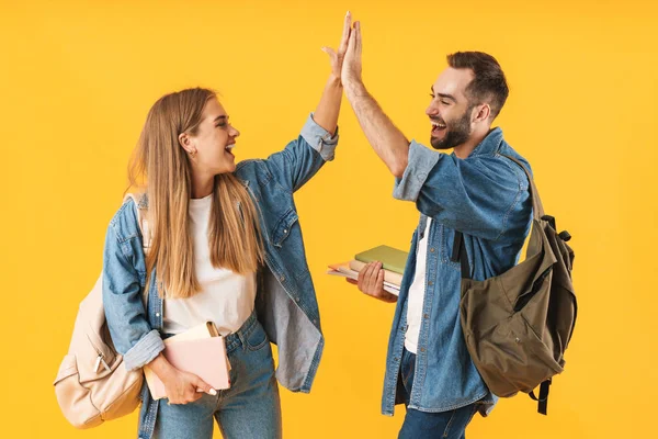 Bild fröhlicher Schüler, die lächeln, während sie Schulhefte in der Hand halten — Stockfoto