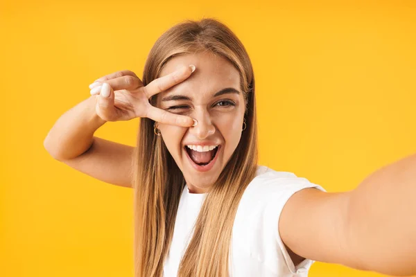 Obraz šťastné ženy ukazující mírovou známku při přijímání selfie — Stock fotografie
