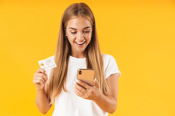 Bild einer fröhlichen Frau, die lächelt, während sie Smartphone und Credi in der Hand hält — Stockfoto