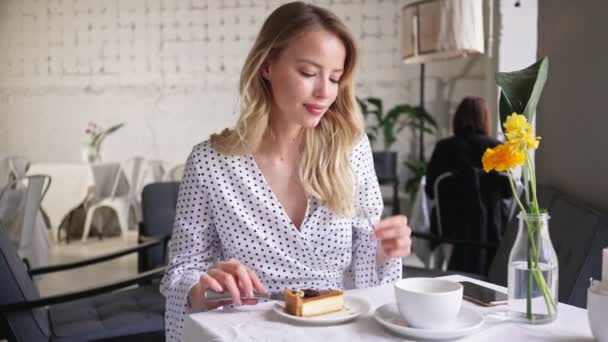 Charmigt Leende Ung Blond Kvinna Äta Cheesecake Och Dricka Kopp — Stockvideo