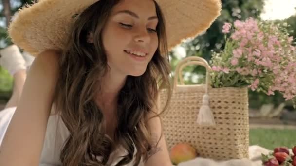Hasır Şapkalı Sevimli Gülümseyen Esmer Kadının Parkta Ekose Üzerinde Yatarken — Stok video