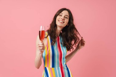 Pozitif sevimli kadın pembe duvar arka plan içme şampanya üzerinde izole poz.