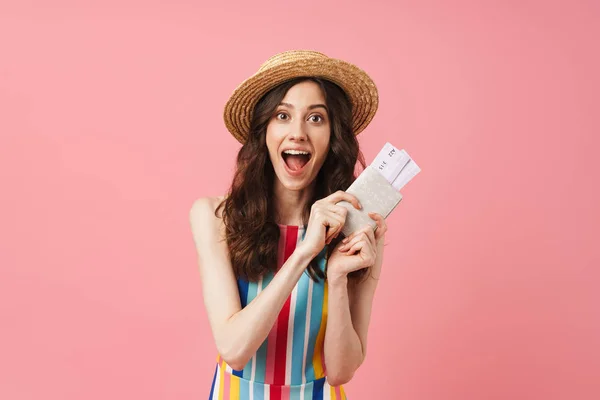 Positive shocked young cute woman posing isolated over pink wall background holding passport with tickets. — Stock Photo, Image