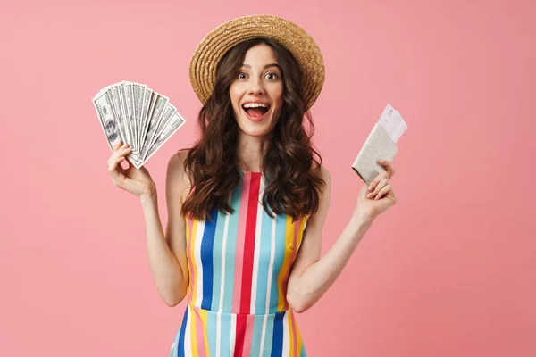 Positivo sorprendido joven linda mujer posando aislado sobre fondo de pared rosa celebración de pasaporte con entradas . — Foto de Stock